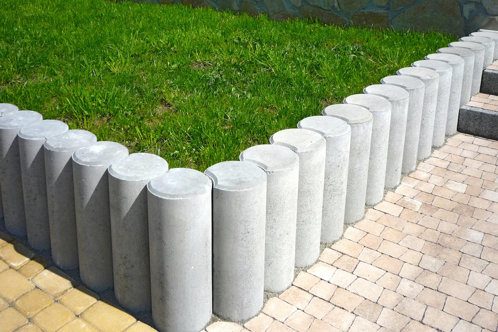 Sharp power-edged border between concrete walk and a green lawn.